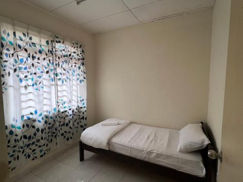 巴西古当Al-Ahsan Homestay的一间卧室设有一张床和一个窗口