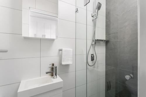 悉尼Studio Apartment in the heart of Newtown NMORE的带淋浴和盥洗盆的白色浴室