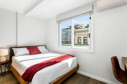 悉尼Studio Apartment in the heart of Newtown NMORE的白色的卧室设有床和窗户