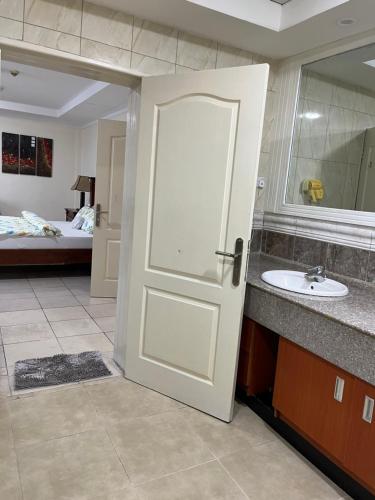 达累斯萨拉姆Mikocheni smart apartment的浴室设有白色门和水槽