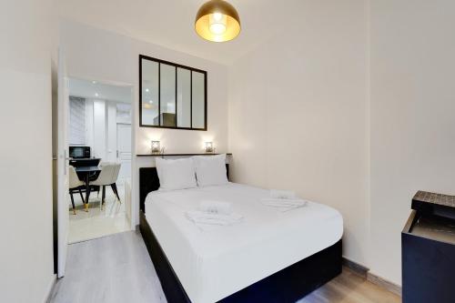 巴黎Comfortable apartment Marx Dormoy的卧室配有白色的床和书桌