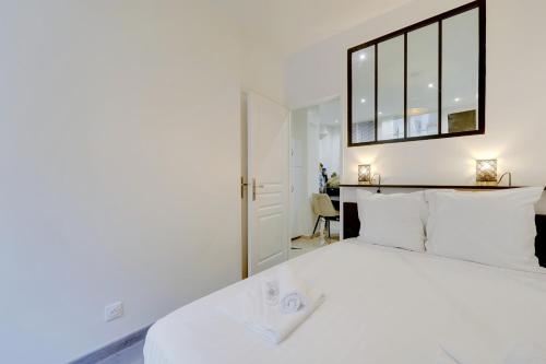 巴黎Comfortable apartment Marx Dormoy的卧室设有一张大白色的床和大窗户