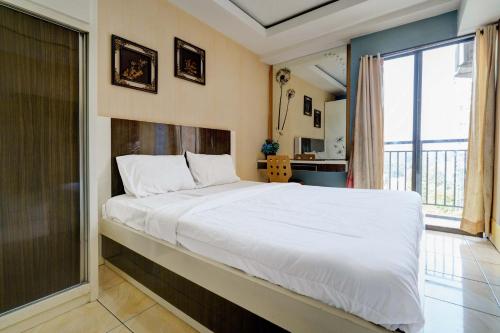 万隆OYO Life 93310 Apartemen Tamansari Panoramic By Santuy 2的一间卧室设有一张大床和一个大窗户