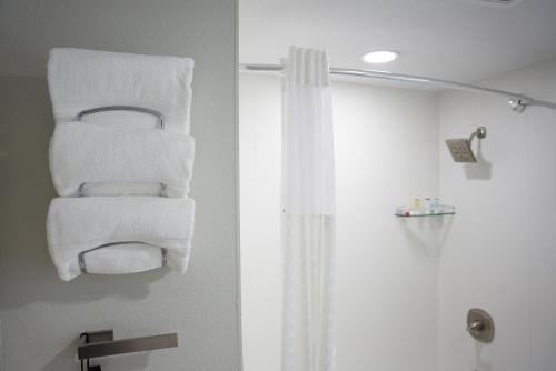 欧文Ramada by Wyndham DFW Airport的浴室毛巾架上的毛巾堆