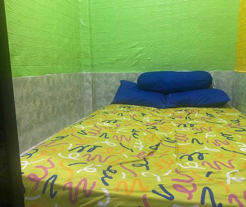 TjakranegaraOYO Life 93401 Kos Putri Alamanda Syariah的绿色墙壁间的一张床位