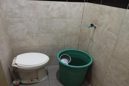 TjakranegaraOYO Life 93403 Penginapan Adinda的浴室设有卫生间和绿色垃圾箱