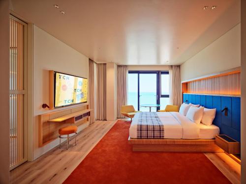 釜山The Coolest Hotel的酒店客房,配有床和电视