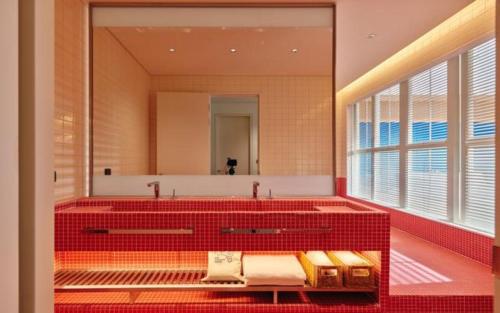 釜山The Coolest Hotel的一间带红色浴缸和大镜子的浴室