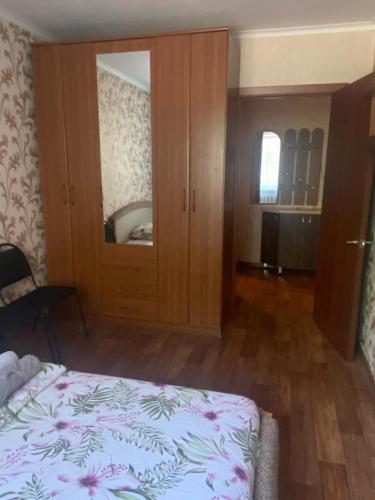 卡拉甘达Тихая теплая уютная однушка的一间卧室配有一张床和一个带镜子的橱柜
