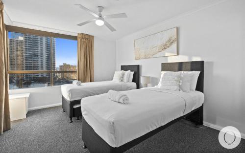 黄金海岸Top of the Mark - Q Stay的一间卧室设有两张床和窗户。