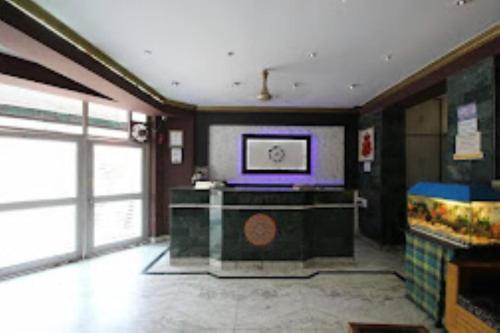 阿格拉Hotel Ajay International Agra的客厅的墙上配有电视