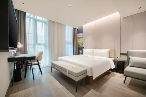 上海上海陆家嘴浦东大道亚朵酒店的卧室配有一张白色大床和一张书桌