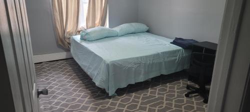 EdgemereRoom in a Beach House with King Size bed in a landlord hosted three bedroom apartment的一张小床,上面有枕头,放在一个房间里
