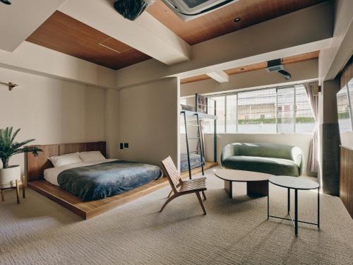 东京illi Mani Shibuya的一间卧室配有一张床、一张沙发和一张桌子