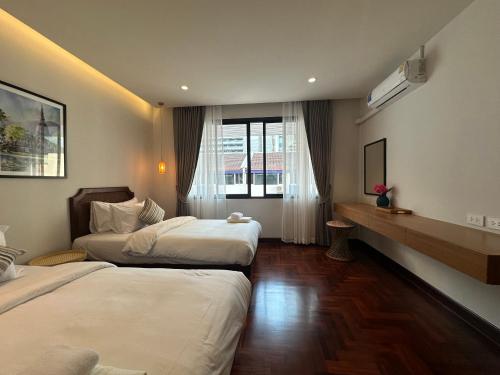 曼谷Bunya House near BTS Asok, Terminal21 private&cozy的酒店客房设有两张床和电视。