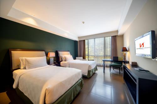 库塔雨林瑞士贝尔酒店的酒店客房设有两张床和一台平面电视。