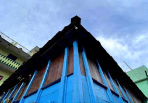 乔斯希马特YATRA HOMESTAY Joshimath的建筑的侧面设有蓝色窗户