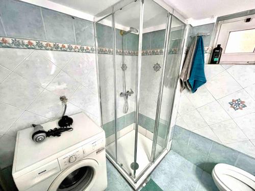塞萨洛尼基Marina Apartmets的带淋浴的浴室内的洗衣机