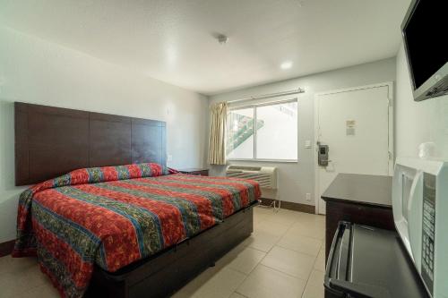 马绍尔Xpress Inn & Extended Stay的一间卧室配有一张床、一张书桌和一个窗户。
