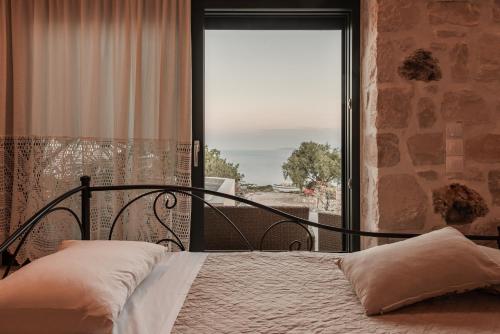 KoríthionAnemos的一间卧室设有一张床和一个大窗户