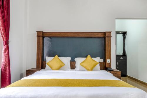 蒙纳FabHotel Abrigo Residency的一间卧室配有一张带黄色枕头的大床