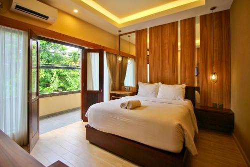 库塔库塔AB酒店的一间卧室设有一张大床和一个大窗户