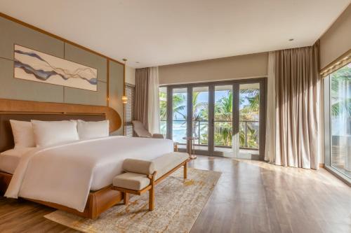 岘港KOI Resort & Residence Da Nang的一间卧室设有一张大床和一个大窗户