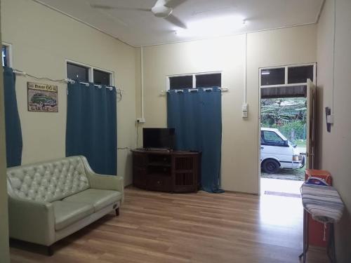 瓜拉丁加奴Bilik Bajet RM70-RM90的带沙发和蓝色窗帘的客厅