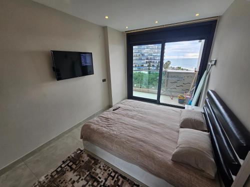 阿拉尼亚Konak Tower Seaside mahmutlar的一间卧室设有一张床和一个大窗户