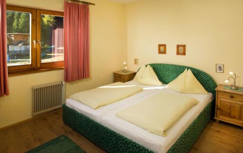 图拉彻霍赫Appartementhaus Turracher Höhe的一间卧室配有带两个枕头的绿色床