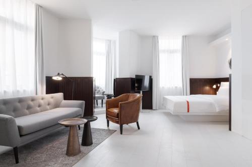斯图加特Ruby Hanna Hotel Stuttgart的酒店客房配有一张床、一张沙发和一张床。