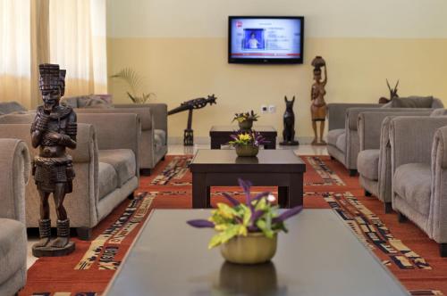 比绍Dunia Hôtel Bissau的客厅配有家具和平面电视。