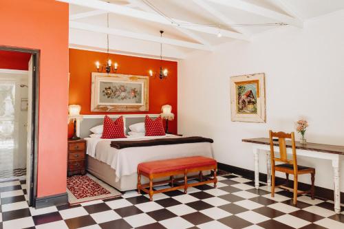 乔治亚考恩宾馆的一间卧室配有一张橙色墙壁和 ⁇ 木地板的床