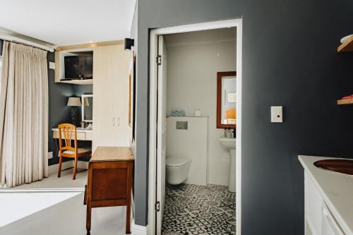 乔治亚考恩宾馆的一间带水槽和卫生间的浴室以及一张书桌。