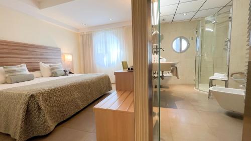 贝尼多姆Riviera Beachotel - Adults Recommended的一间卧室配有一张床、淋浴和盥洗盆