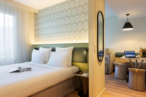 巴黎巴黎馨乐庭顶级酒店的配有一张床和一张书桌的酒店客房
