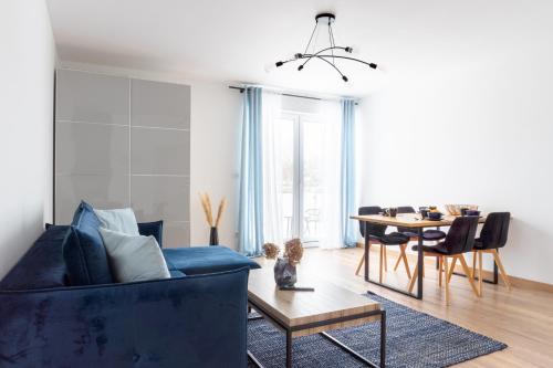 加茨比亚格拉Apartamenty Sea Colors - Nowoczesne i Komfortowe Apartamenty w Jastrzębiej Górze的客厅配有蓝色的沙发和桌子
