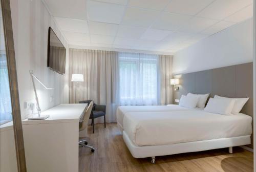 费尔德霍芬康宁小夫NH埃因霍温会议中心酒店的酒店客房设有一张白色大床和一张书桌