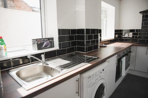 莱斯特Leicester Park House的厨房配有水槽和洗衣机