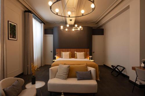 法尔肯堡Hotel Kint的一间卧室配有一张床、一张沙发和一个吊灯。