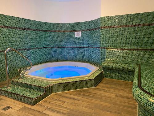 玛塔弗瑞德萨斯托酒店的绿色瓷砖客房内的按摩浴缸