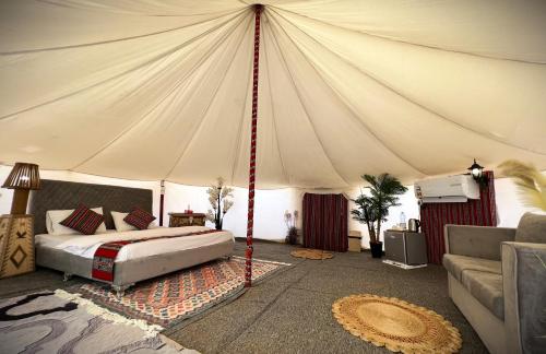 BadīyahAl Salam Desert Camp Bidiya的帐篷内一间卧室,配有一张床
