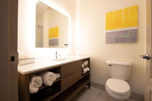 拉斐特Comfort Suites Oil Center的一间带卫生间、水槽和镜子的浴室