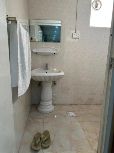 沙迦Al Ramla, Na’eem Bin Masoud St#8, Villa#10的浴室设有水槽、镜子和2双鞋