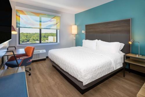 彭萨科拉Tru By Hilton Pensacola Airport Medical Center的酒店客房配有一张床、一张桌子和一把椅子。