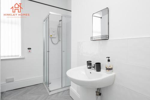 利物浦Spacious 5-Bedroom Oasis with Games Room-Liverpool的白色的浴室设有水槽和淋浴。