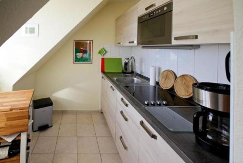 奥斯赛拜-屈隆斯博恩Strandschloesschen-Haus-II-WE-21-9820的厨房配有水槽和台面