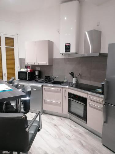 尼斯Dolce vita的一间厨房,配有白色家电和桌椅