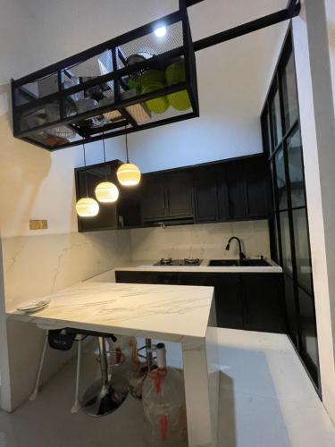 岩望seVilla Guest House Pasuruan的厨房配有黑色橱柜和白色桌子