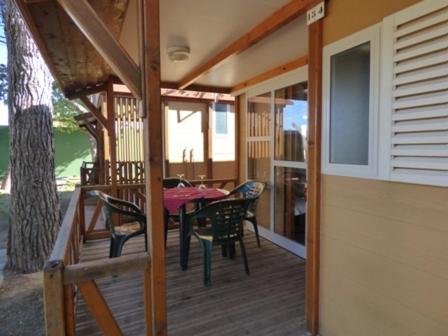 苏埃卡Camping Barraquetes的甲板上配有桌椅的房子